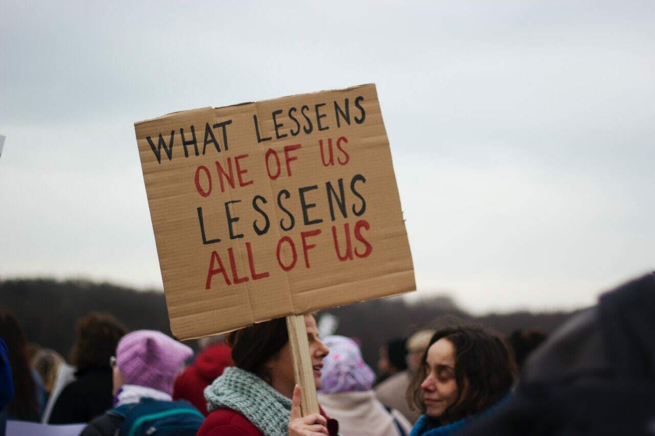 Demonstrators holding a sign up with the caption 