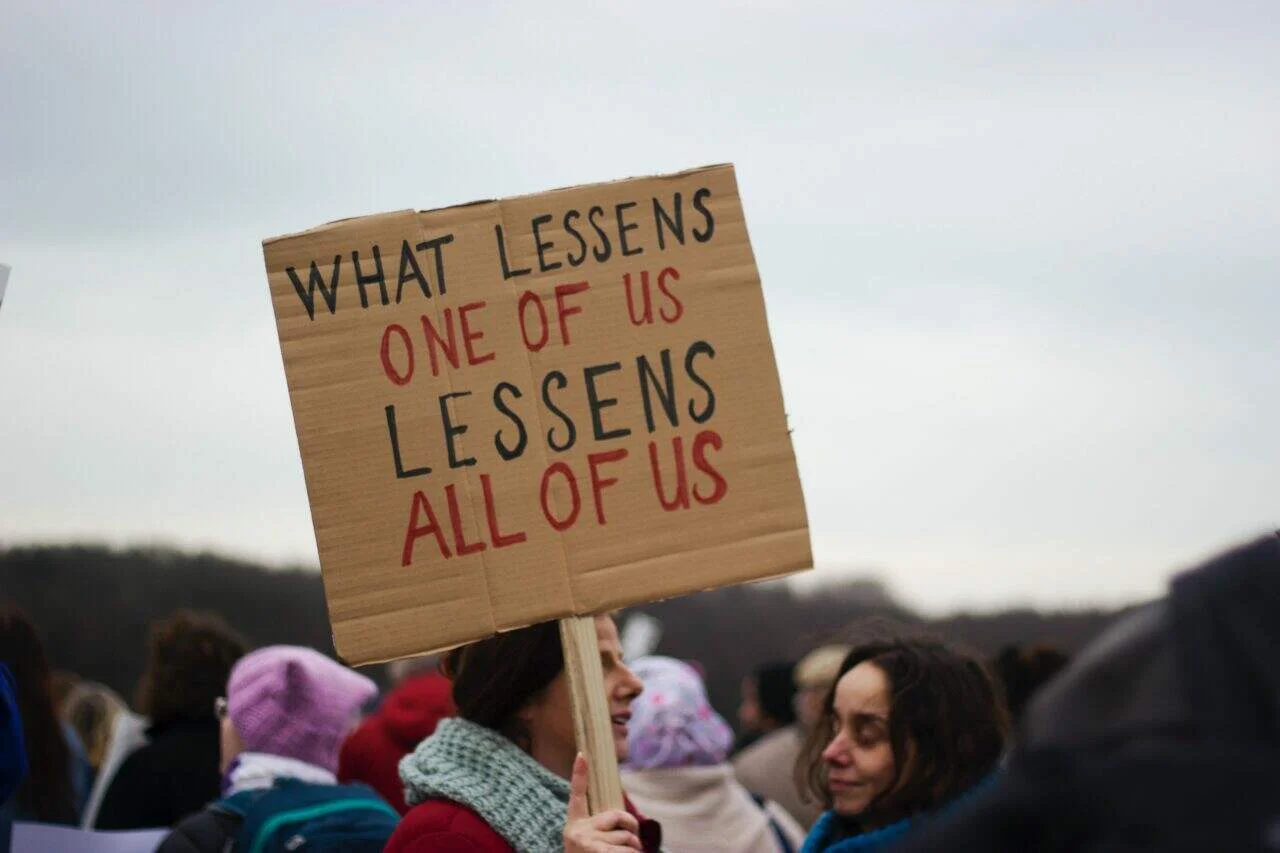 Demonstrators holding a sign up with the caption